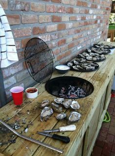 an outdoor bbq with oysters on the grill