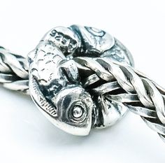 Authentic TROLLBEADS Happy Fish Bead Sterling Silver Charm TAGBE-10098 RETIRED by Designer Søren Nielsen. This bead features two Sterling Silver fish that seem to be dancing around each other in a circle. Hence the name Happy Fish. A very rare bead that was first introduced in 2004 and retired in 2014. Charm is pre-owned and in great condition. This item is retired from production and may be difficult to find.  All precious metal items have been tested and verified by our Thermo Scientific Niton DXL Xray Scanner. All gemstones are authenticated using the Presidium Gem Tester II. Note: TROLLBEADS charms are designed to fit TROLLBEADS bracelets only. Most of them have a smaller core and will not fit European style bracelets such as Pandora.  All my jewelry items come in a black velvet jewelr Trollbeads Bracelet, Fish Beads, Rare Beads, Silver Fish, Pandora Bracelets, A Circle, Pandora Bracelet, Jewelry Pouch, Sterling Silver Charm