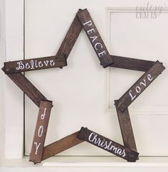 a wooden star with words on it hanging from the side of a white door that says believe, peace, love, joy and joy