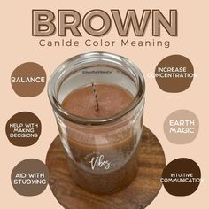 a brown candle sitting on top of a wooden table next to a glass jar filled with liquid