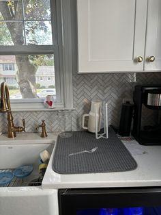 a kitchen with a sink, microwave and window in the back drop off cabinet area