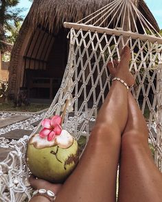 a person laying in a hammock with a coconut and flower decoration on it