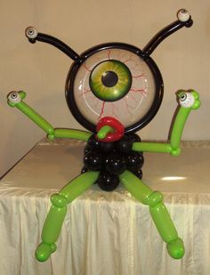 a balloon sculpture with an eyeball in the shape of a spider sitting on top of a table