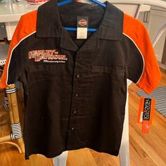 New With Tags, Authentic Harley-Davidson, Button Down, Classic, Short Sleeved Shirt. Size 6 But Runs Small. Black Cotton Tops With Snap Buttons, Black And Orange Dress, Harley Davidson Kids, Harley Davidson Patches, Vintage Harley Davidson Shirt, Harley Davidson Tank Tops, Button Shirts, New Harley Davidson, Tan Plaid