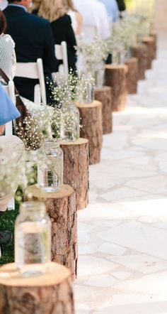 a row of chairs with vases filled with baby's breath flowers