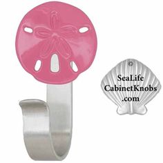 a pink sand dollar shaped bottle opener with a sea life design on it's side