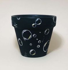 a black pot with white and yellow designs on it