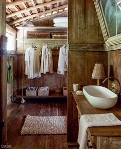 a bathroom with wooden walls and flooring next to a white sink on a counter