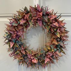 an origami wreath hanging on the front door