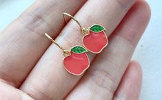 These red / green apple earrings are dainty and kawaii. They are made of the followings: (1) Gold plated enamel apple charm (10 x 11 mm) (2) Gold plated or 14KGF earring hooks ✏️ Please choose your desired color of apple charm ✏️ Please choose your desired plating of earring hooks 🍎 NECKLACE 🍏 → https://www.etsy.com/listing/1026344723 【BEFORE PURCHASE, PLEASE NOTE THE FOLLOWINGS】 ☆ VAT, GST and any other taxes from your country are NOT included in the listing price. Buyers are responsible for Cute Red Earrings With Fruit Design, Cute Red Enamel Earrings, Cute Fruit Design Jewelry For Gifts, Cute Fruit Design Jewelry As Gift, Handmade Red Kawaii Jewelry, Cute Red Round Jewelry, Cute Round Red Jewelry, Apple Jewelry, Ring Charm Necklace