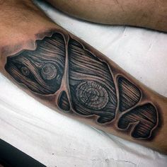 a man's leg with a fish tattoo on it, and some wood in the background