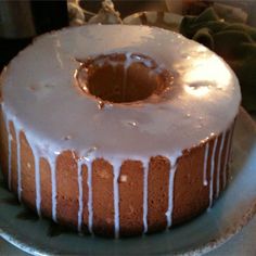 a bundt cake with icing sitting on top of a silver platter,