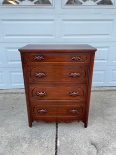 a wooden dresser sitting in front of a garage door