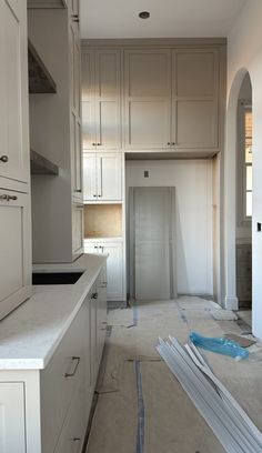 an empty kitchen is being remodeled with white cabinets