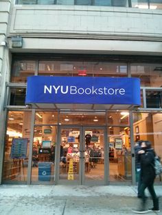 people are walking in front of the new york book store, which is open for business