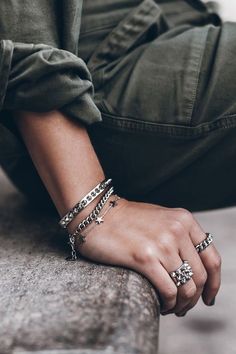 a person sitting on the ground wearing bracelets