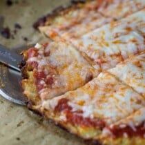 a close up of a sliced pizza on a cutting board