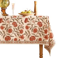 an embroidered table cloth with flowers and leaves on it