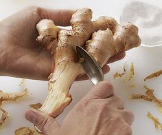 a person is peeling ginger root with a knife