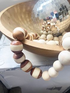 a wooden bead necklace with disco ball and mirror in the backgrouund