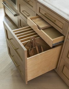 an open drawer in the middle of a kitchen