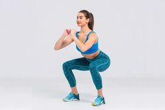 a woman in blue top and leggings doing squat exercises