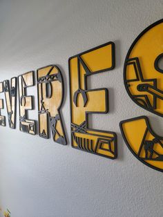 three metal letters are mounted on the wall