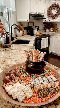 a platter filled with cookies and candy on top of a kitchen counter next to an oven