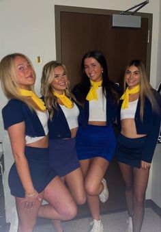 four beautiful women posing for the camera in front of a door with yellow scarfs