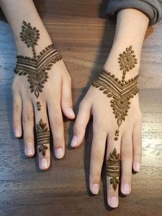 two hands with henna tattoos on them