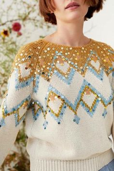 a woman wearing a sweater with sequins on it