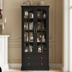 a tall black cabinet with glass doors next to a fireplace