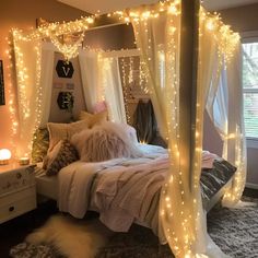 a bed with lights on the headboard and canopy over it in a bedroom decorated for christmas