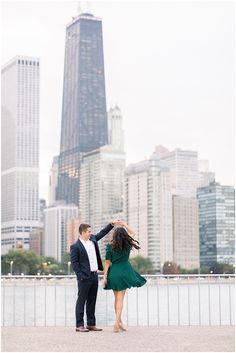 an engaged couple dancing in front of the chicago skyline