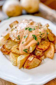 a white plate topped with potatoes covered in gravy