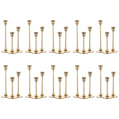 a set of twelve brass candlesticks in various sizes and shapes, all lined up against one another