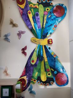 a colorful butterfly made out of paper on the wall