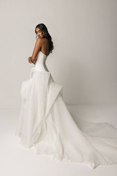 a woman in a white dress is posing for the camera