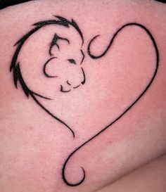 a small tattoo on the back of a woman's thigh, with a cat in the shape of a heart