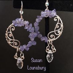 the earrings are made with silver wire and amethorate beads, which have been handcrafted by susan lounsbury