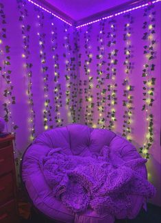 a purple chair sitting in front of a wall with lights