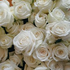 a bunch of white roses are arranged together