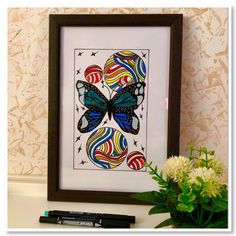 a framed art piece with a butterfly on it