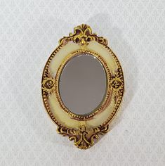 an ornately decorated mirror is shown on a white surface with gold trimmings