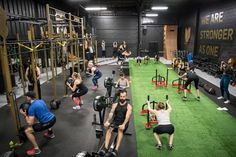 a group of people doing squats in a crossfit gym with exercise equipment