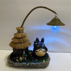 a lamp that is sitting on top of a small rock with a dog figurine next to it