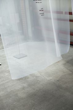 a white piece of paper sitting on top of a cement floor next to a window