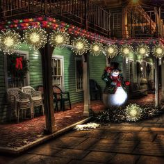 a house decorated for christmas with lights and decorations on the front porch, including a snowman