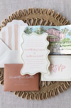 the wedding stationery is laid out on a wicker plate