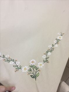 someone is stitching flowers on a piece of cloth